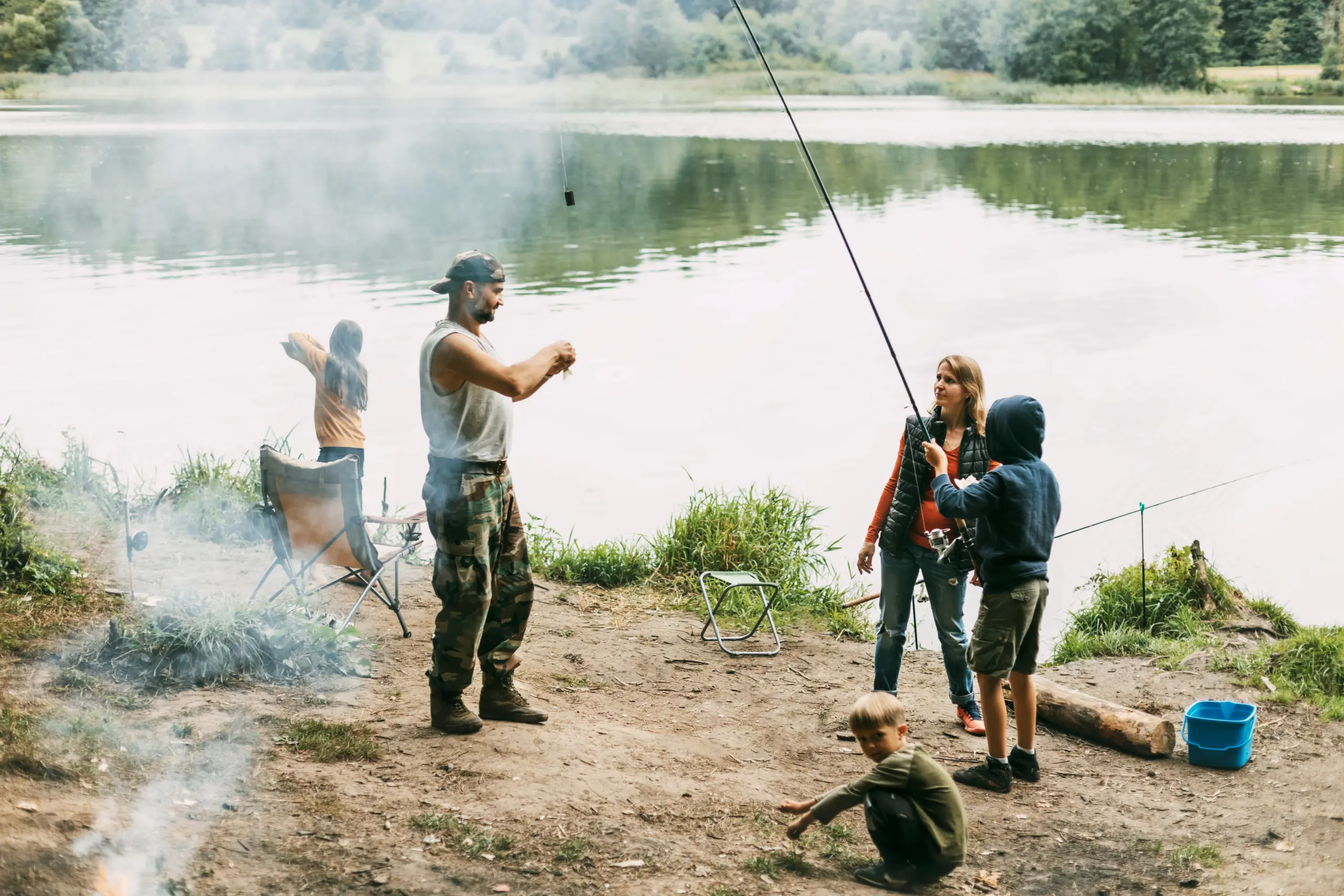 A happy family is fishing on the bank of a river or lake. Spending time together, family time, family vacation